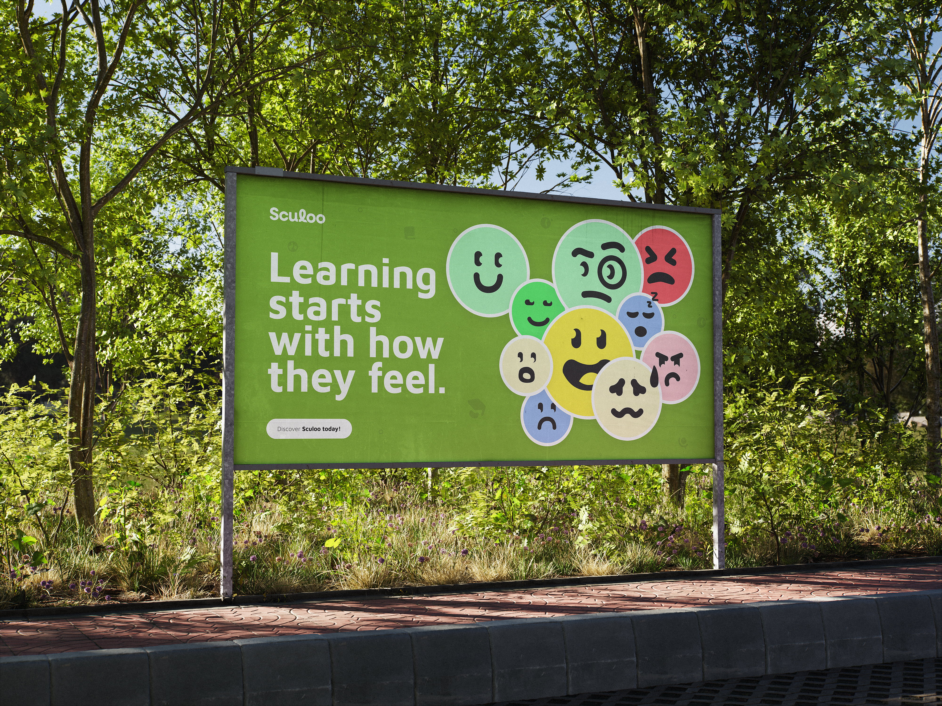 A green Sculoo billboard among trees beside a path, reading “Learning starts with how they feel.” and “Discover Sculoo today!”, beside a cluster of colourful faces