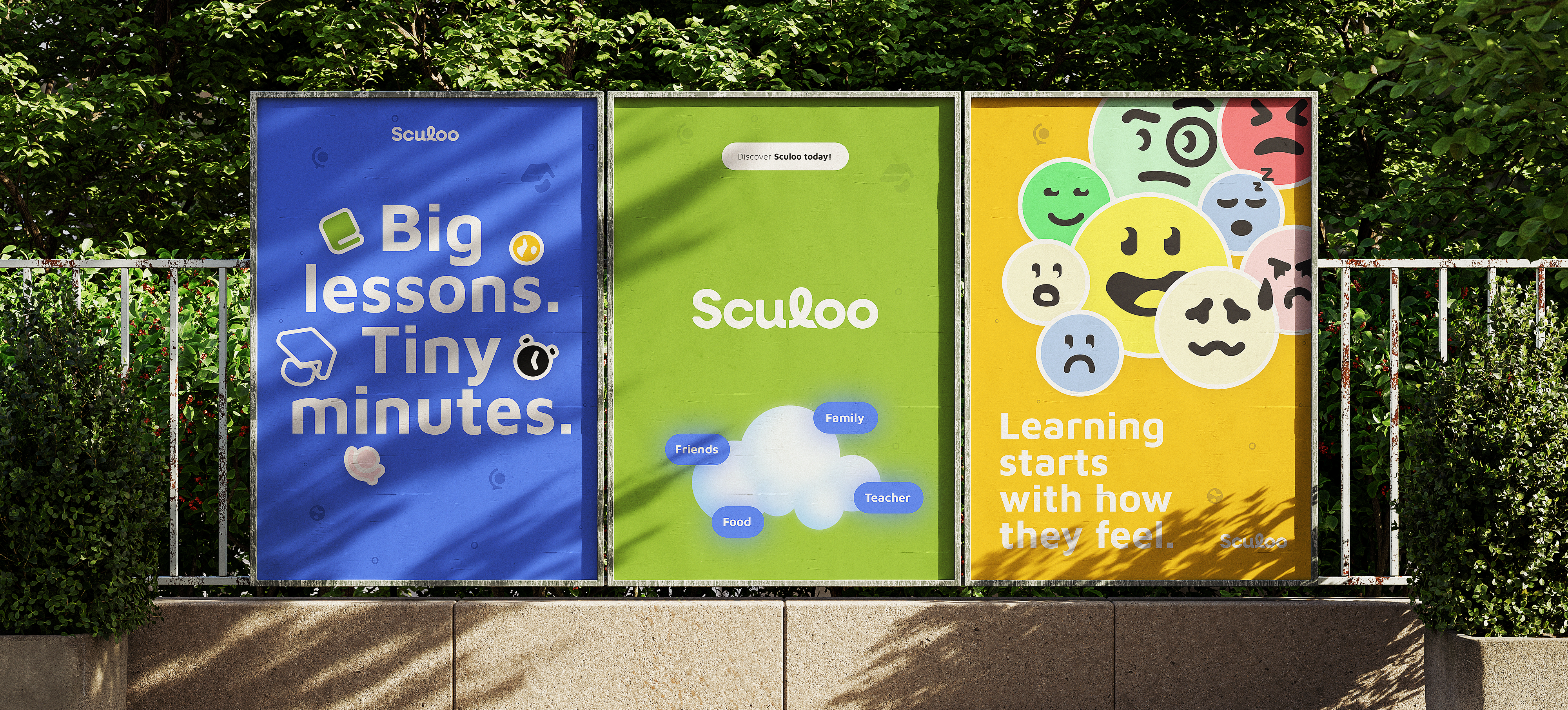 Three Sculoo posters in a row against a railing and hedge: blue reading “Big lessons. Tiny minutes.”, green with the wordmark over a cloud tagged friends, family, teacher and food, and yellow covered in faces reading “Learning starts with how they feel.”